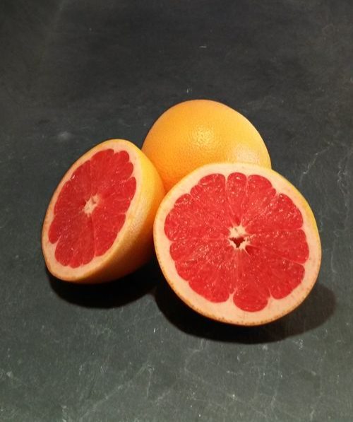 Foto einer aufgeschnittenen und einer ganzen Pink Grapefruit